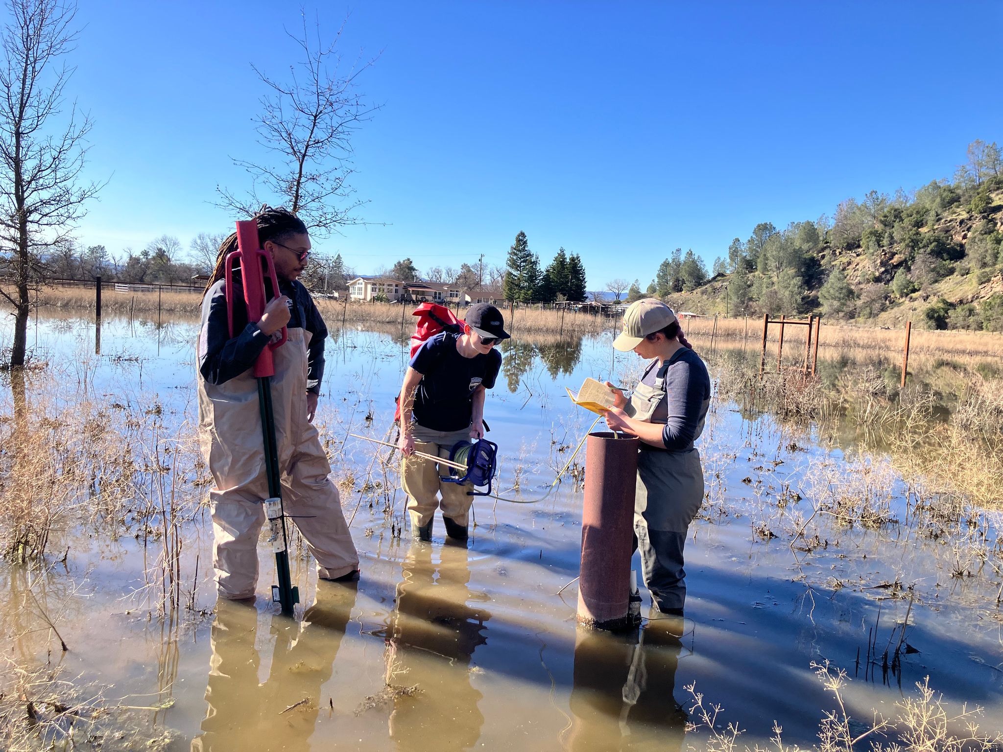 State Water Board staff installing a monitoring gauge in pasture well
